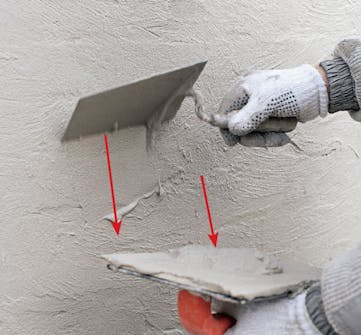 Tiiliseinän rappaus: Laastia raavitaan pois pinnasta muurauslastalla Tiiliseinän rappaus: Laastia raavitaan pois pinnasta muurauslastalla